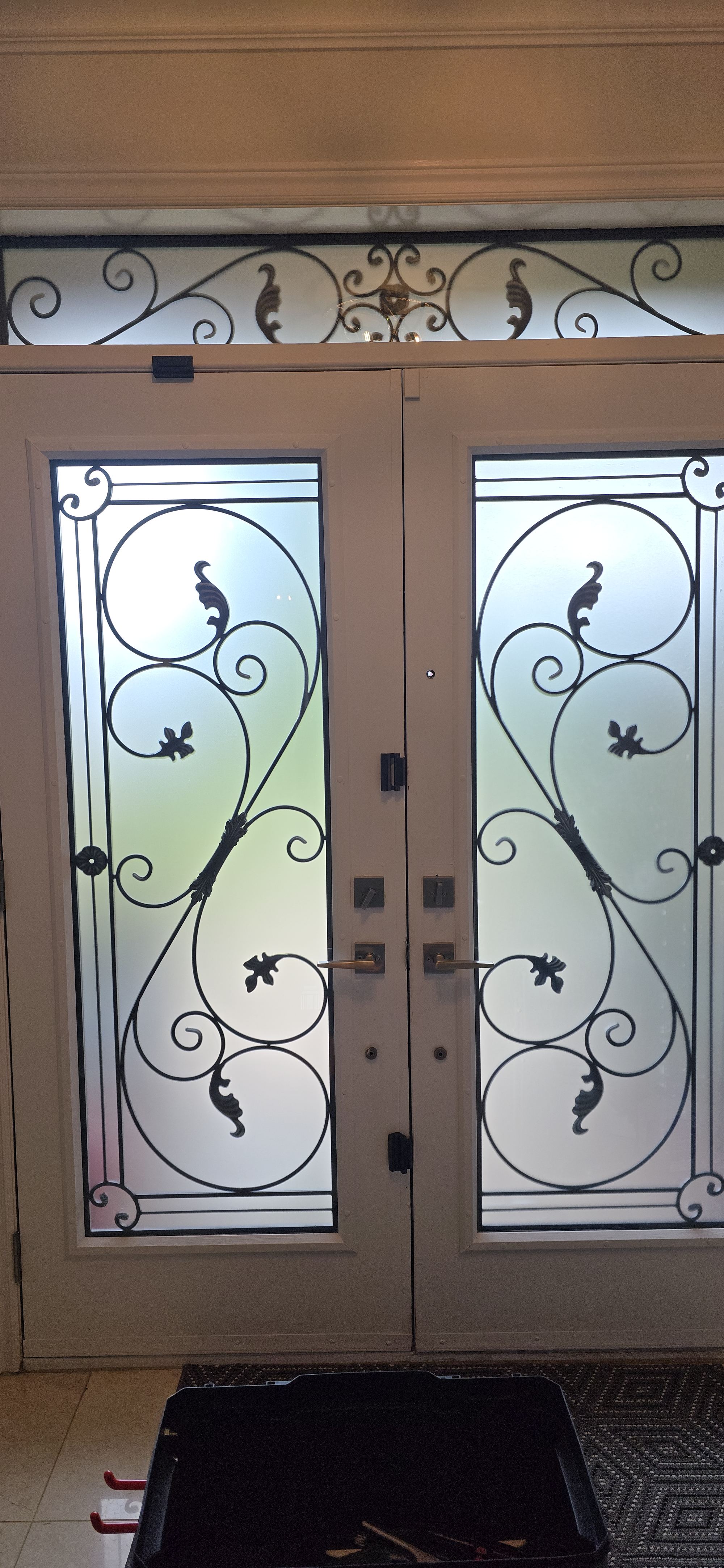 Double entry doors with decorative ironwork and standard frosted privacy film